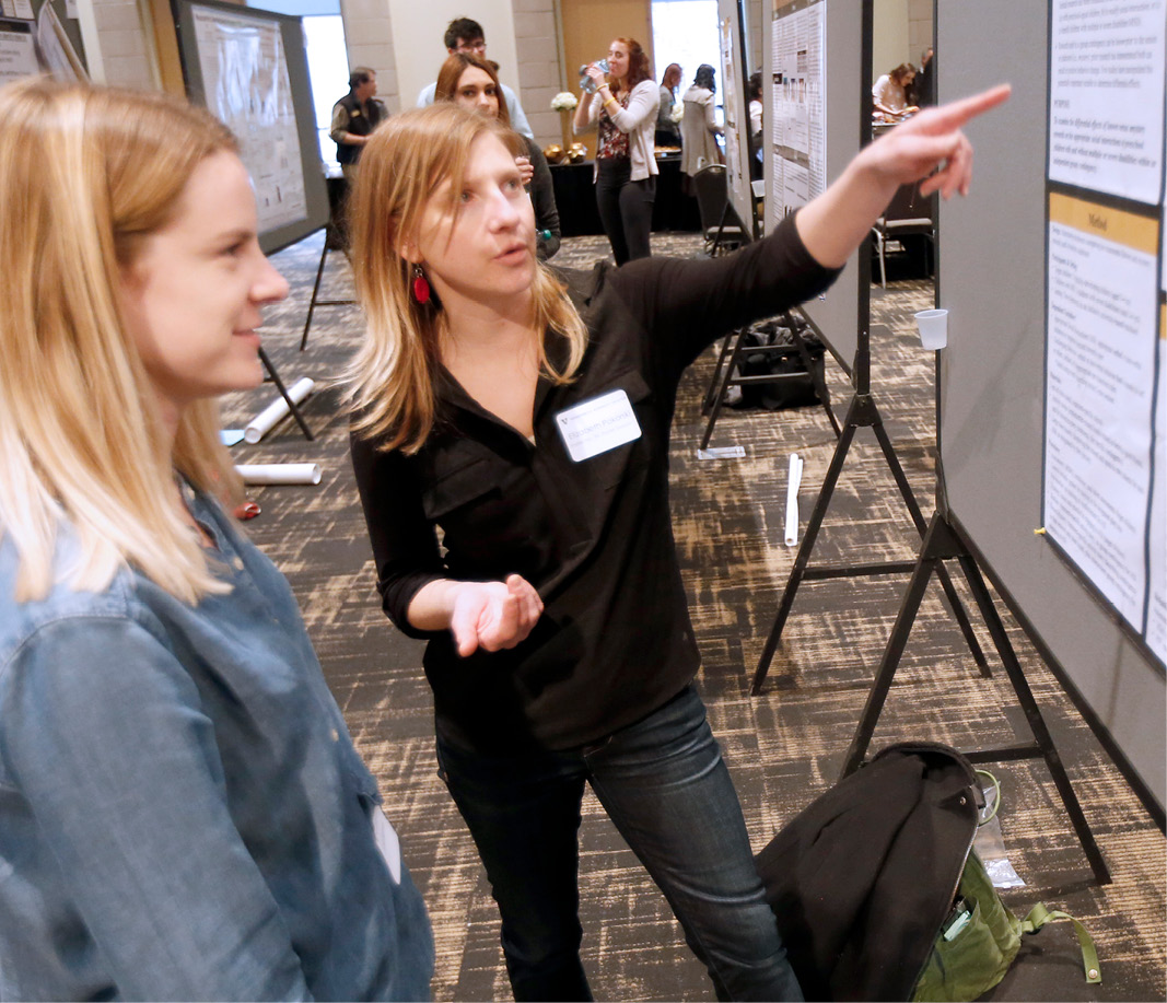 Two women talking and looking at poster at Science Day