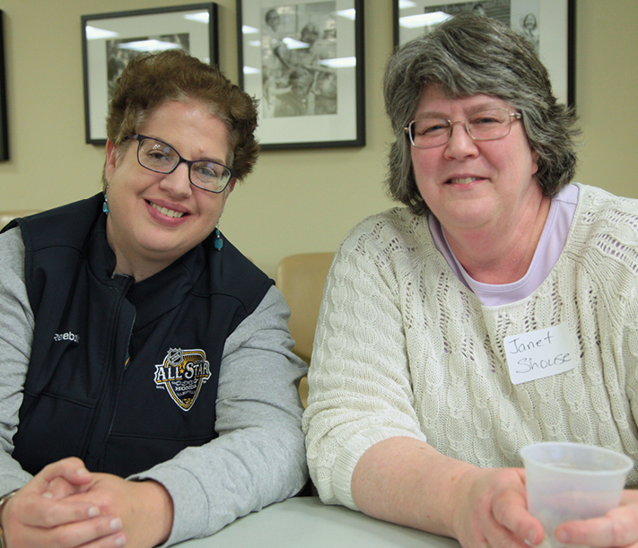Two women sitting at a table at a Putting Faith to Work meeting